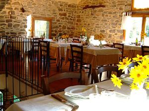 a dining room with tables and chairs with yellow flowers at la cartiera dei benandanti in Monghidoro