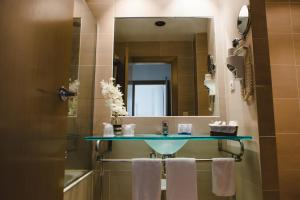 a bathroom with a sink and a mirror and towels at Hotel Mas Camarena in Paterna