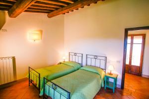 2 camas en una habitación con 2 lámparas en las mesas en Fattoria Abbazia Monte Oliveto, en San Gimignano