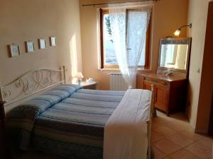 a hotel room with a bed and a dresser at Agriturismo La Manonera in Montepulciano