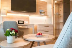 ein Zimmer mit einem Stuhl und einem Tisch mit einer Obstschale in der Unterkunft Hotel Altes Zollhaus in Horumersiel