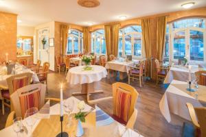 ein Restaurant mit Tischen und Stühlen und Fenstern in der Unterkunft Hotel Altes Zollhaus in Horumersiel