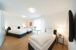 ein Hotelzimmer mit 2 Betten und einem Sofa in der Unterkunft „by Hotel Meyer“ City Apartments in Hannover