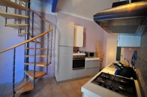 a kitchen with a stove and a spiral staircase at Blue House in Alghero