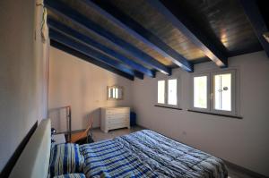 a bedroom with a bed and two windows at Blue House in Alghero