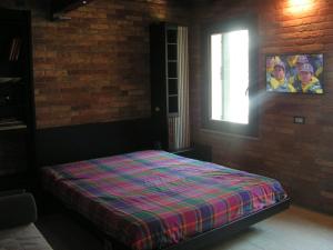 um quarto com uma cama numa parede de tijolos em Cocoloco em Veneza