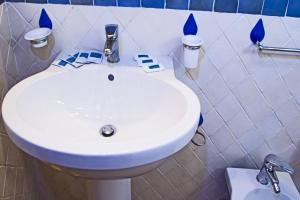 チェファルにあるCasa Ifigeniaのバスルーム(青色のアクセントの白い洗面台付)