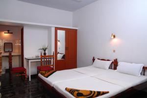 a bedroom with a large white bed and a desk at Hotel Sea View Palace - the beach hotel in Kovalam