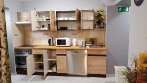 eine kleine Küche mit einer Spüle und einer Mikrowelle in der Unterkunft Apartament Grosik in Duszniki-Zdrój