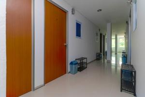 un corridoio vuoto con una porta arancione in un edificio di RedDoorz Plus near Kepri Mall a Batam Center
