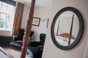 a round mirror with a bed in a room at The Bridge House in Ross on Wye