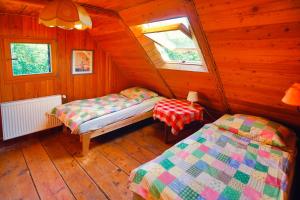 a bedroom with two beds in a wooden cabin at Dom Przysłupowy Educare -Agroturystyka Slow Food in Świeradów-Zdrój