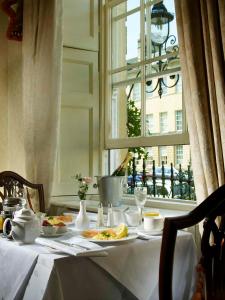 una mesa con platos de comida y una ventana en The Windsor Town House, en Bath