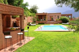 un cortile con piscina e prato di Domaine La Source a Ouirgane