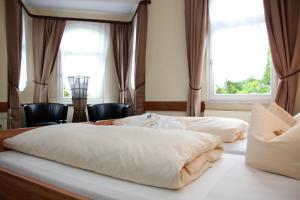 2 Betten in einem Hotelzimmer mit 2 Fenstern in der Unterkunft Hotel Schober am Kurpark in Bad Salzschlirf