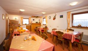 ein Restaurant mit Tischen und Stühlen in einem Zimmer in der Unterkunft Gästehaus Helga in Längenfeld