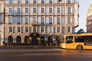 a yellow bus parked in front of a large building at Hotel Alexandra in Copenhagen