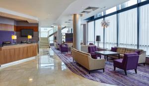 - un hall avec des chaises violettes et une table dans l'établissement Leonardo Hotel Milton Keynes, à Milton Keynes