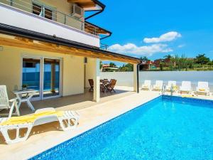 a villa with a swimming pool and a house at Villa Sanja in Plovanija
