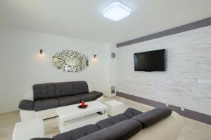 a living room with two couches and a tv on a brick wall at Villa Sanja in Plovanija