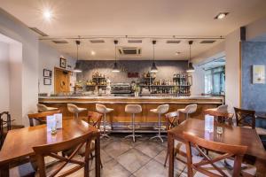 un restaurante con mesas de madera y un bar en Hotel Villa Virginia, en Sabiñánigo