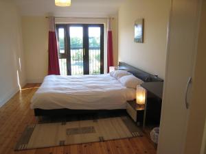 a bedroom with a large bed and a window at Holiday Home Grove Lodge-2 by Interhome in Killorglin