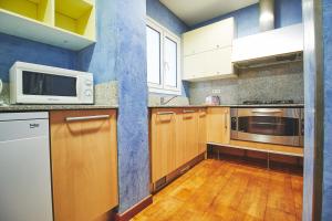 a kitchen with wooden cabinets and a microwave at Alcam Plaza Cataluña in Barcelona +16 photos