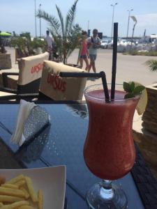 a drink on a table with a plate of french fries at Hotel Laguna in Mangalia