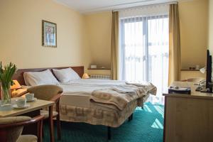 a hotel room with a bed and a window at Hotel Aleksander in Ustka
