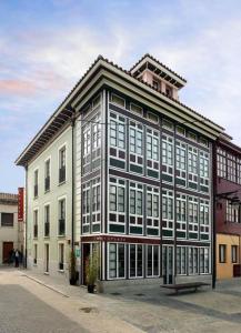 a large building with many windows on a street at La Plaza I in Luanco