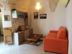 a living room with an orange couch and a table at A' Puteja in Ceglie Messapica