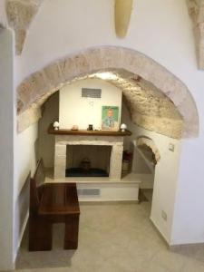 a living room with a stone fireplace and a table at A' Puteja in Ceglie Messapica