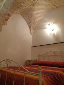 a bedroom with two beds with orange sheets and a ceiling at A' Puteja in Ceglie Messapica