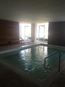a large swimming pool with green water in a building at Apartamento Forest 2 in Punta del Este