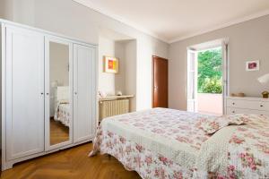 a white bedroom with a bed and a window at Rio Molino in Stresa