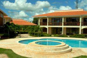 una casa con piscina di fronte a una casa di Green Paradise a Juan Dolio