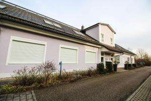 Casa blanca con ventanas con persianas en una calle en Hotel Ferchenhof en Múnich