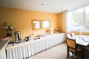 Hotel Ferchenhof في ميونخ: غرفة طعام مع طابور طويل من الطاولات