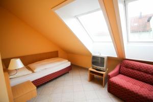 1 dormitorio con 1 cama, TV y silla en Hotel Ferchenhof en Múnich