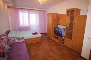 スィクティフカルにあるComfort apartment on Pervomayskaya 20のベッド1台、テレビが備わる小さな客室です。