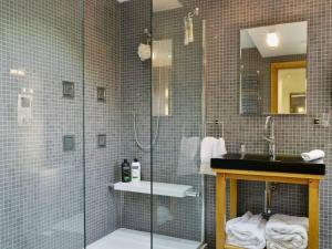 a bathroom with a glass shower and a sink at Saddleback Penthouse in Penrith