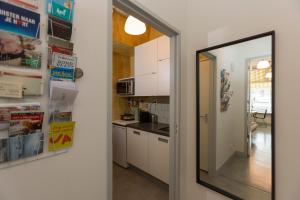 una cucina con armadietti bianchi e specchio di VeenkadeBnB a L'Aia