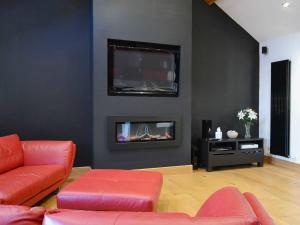 een woonkamer met een bank en een open haard bij Saddleback Penthouse in Penrith