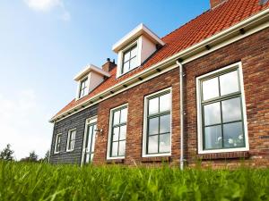 a brick building with windows on top of a field of grass at Holiday Home Ganuenta-1 by Interhome in Colijnsplaat