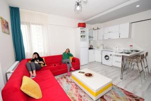 two women sitting on a red couch in a living room at Talas Loft Residence in Kayseri