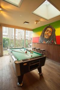 
a living room with a pool table and a painting on the wall at The Flying Pig Uptown in Amsterdam
