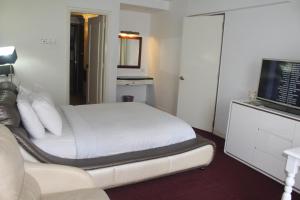 um quarto de hotel com uma cama e uma televisão de ecrã plano em Best Apartment at Times Square em Kuala Lumpur