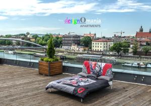 a couch on a balcony with a view of a river at Designomania Apartments - Nadwiślańska 11 in Krakow