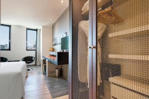 a room with a bed and a walk in shower at Hotel Barcelona Condal Mar Affiliated by Meliá in Barcelona