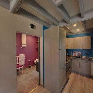 a kitchen with purple walls and a refrigerator at Gite La Ferme du Grand Air in Fiennes